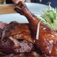 Peking Duck sliced with the leg aloft in the center of the platter